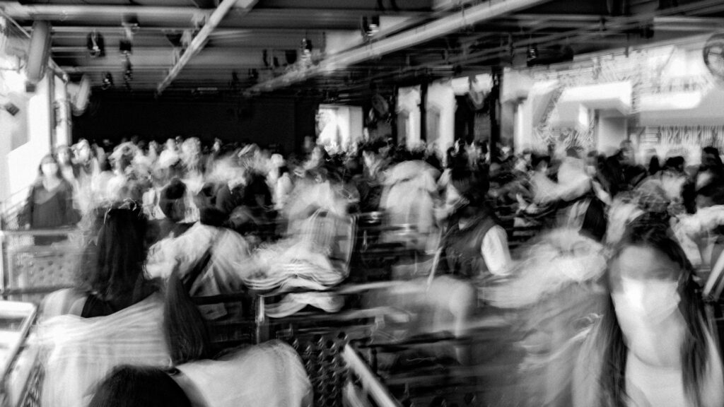 A black and white blurred photo of a room of people.