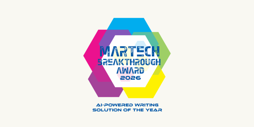 Hexagons in blue, pink, green, and yellow behind text: Martech Breakthrough Award 2026. Below: AI-Powered Writing Solution of the Year in blue. White background.