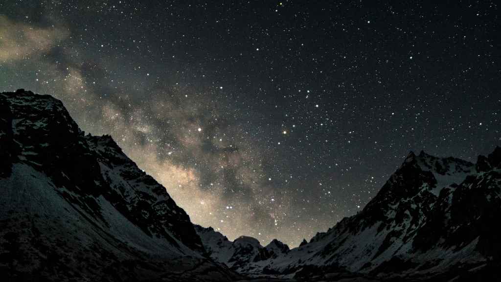 Snow-capped mountains at night with a sky full of stars and the Milky Way clearly visible above the peaks, creating a breathtaking scene that could make you pause to verify if such beauty is truly real—or just remarkably vivid AI content.