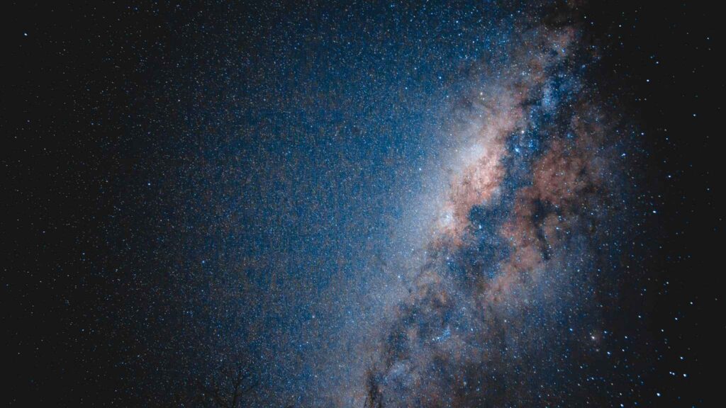 A dense star field showing the Milky Way galaxy against a dark night sky, with bright clusters and swirling clouds of interstellar dust and gas.
